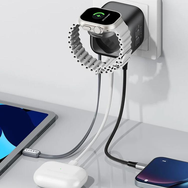 GaN travel charger with retractable cable connected to a phone at a wall outlet