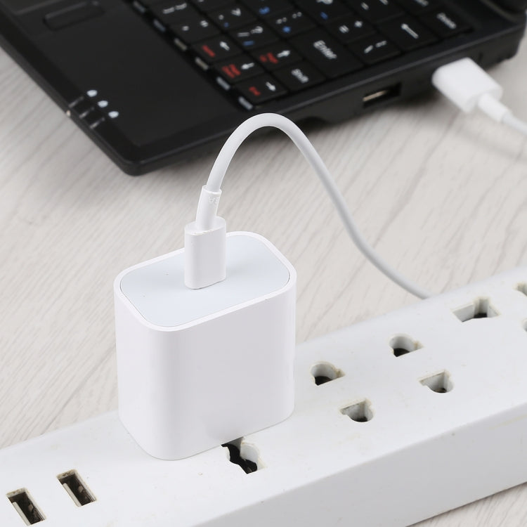 White USB-C PD charger adapter plugged into a wall outlet, US plug