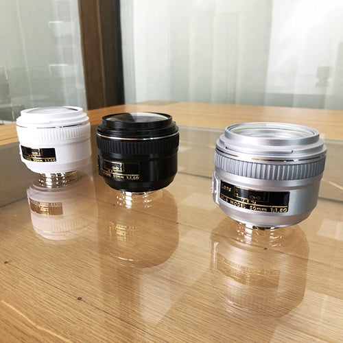 Set of three fake camera lens models in silver, black, and white with mounts