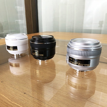 Set of three fake camera lens models in silver, black, and white with mounts
