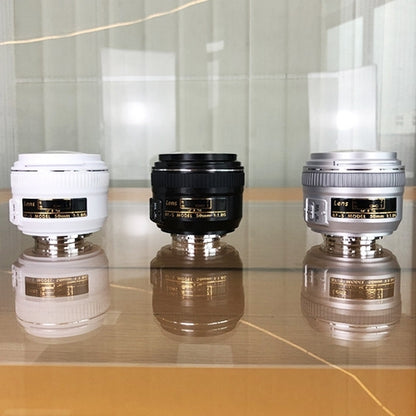 Three fake camera lens models showing top barrels in white, black, and silver