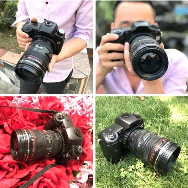 Black dummy DSLR camera prop held with attached lens
