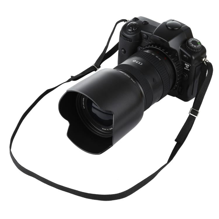 Black fake DSLR camera prop with attached lens and wide strap.