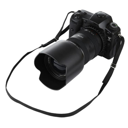 Black fake DSLR camera prop with attached lens and wide strap.