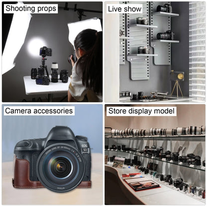 Studio display of fake DSLR camera prop with accessories and lens.