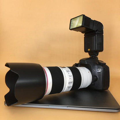 Black DSLR dummy with long white telephoto lens and top-mounted flash