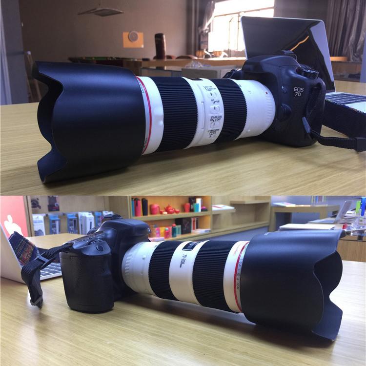 Black camera and telephoto lens dummy prop lying on tabletop with strap