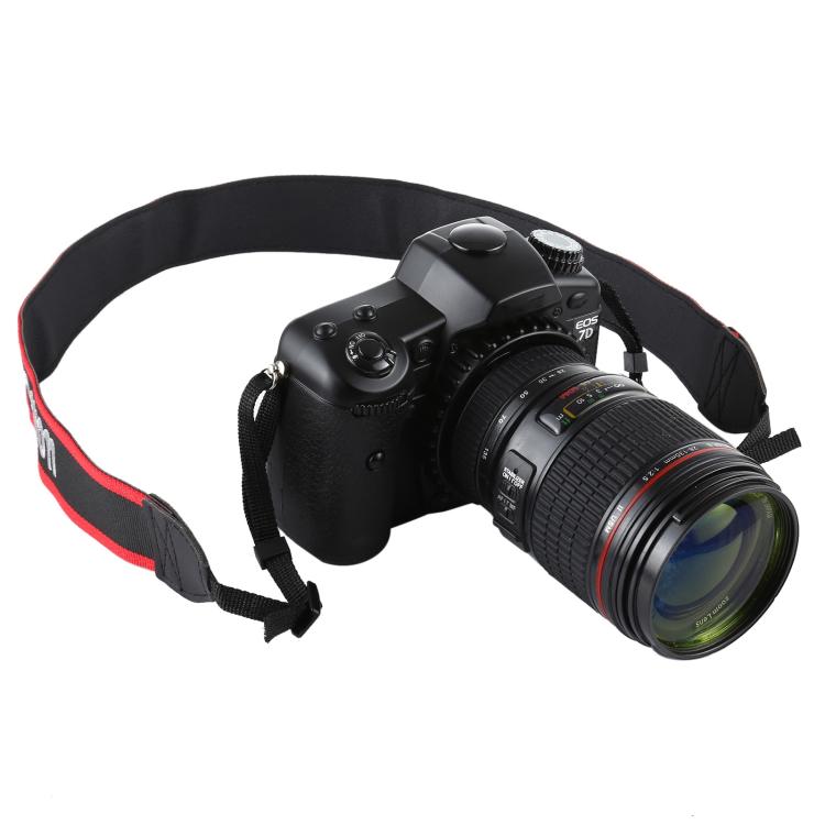 Black DSLR camera prop with large lens and red-and-black shoulder strap