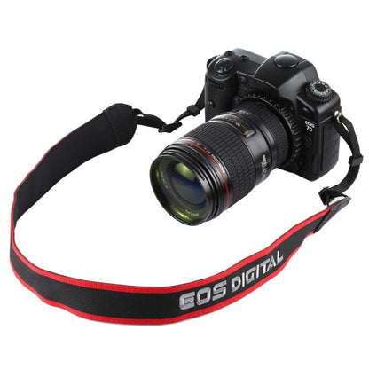 Black DSLR camera prop with attached zoom lens and red EOS Digital strap