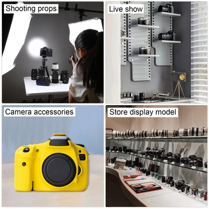 Black DSLR camera prop on display with lens and strap among studio accessories