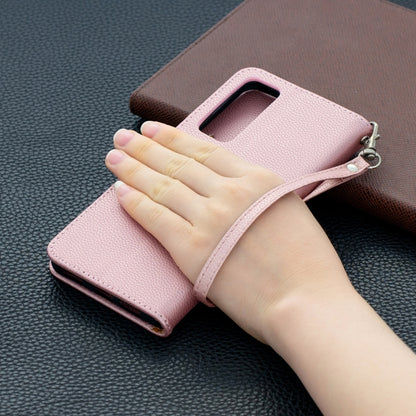 Rose gold textured flip phone wallet case held in hand, with wrist strap
