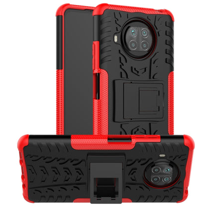 Red rugged tablet case with textured back, camera cutout, and holder stand