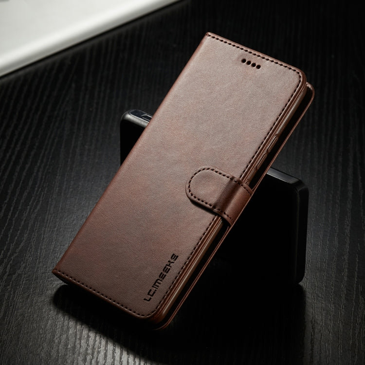 Brown leather flip phone case closed with stitched flap and side edges; front speaker holes.