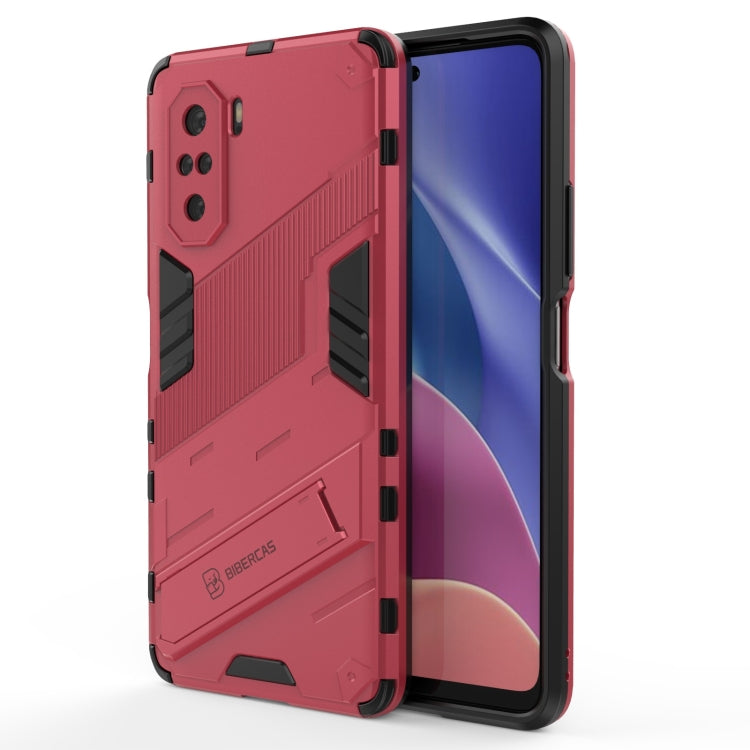 Rugged shockproof phone case with holder, red back with black grips, phone display visible.