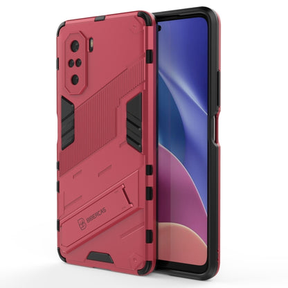 Rugged shockproof phone case with holder, red back with black grips, phone display visible.