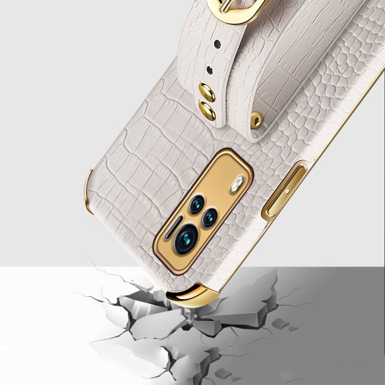 White croc-pattern TPU case with wrist strap and gold-tone buttons, close-up