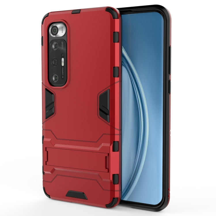 Rugged protective phone case in red with armor panels and button cutouts near camera
