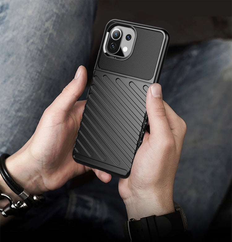 Black ribbed TPU phone case held in hands, with raised camera bezel