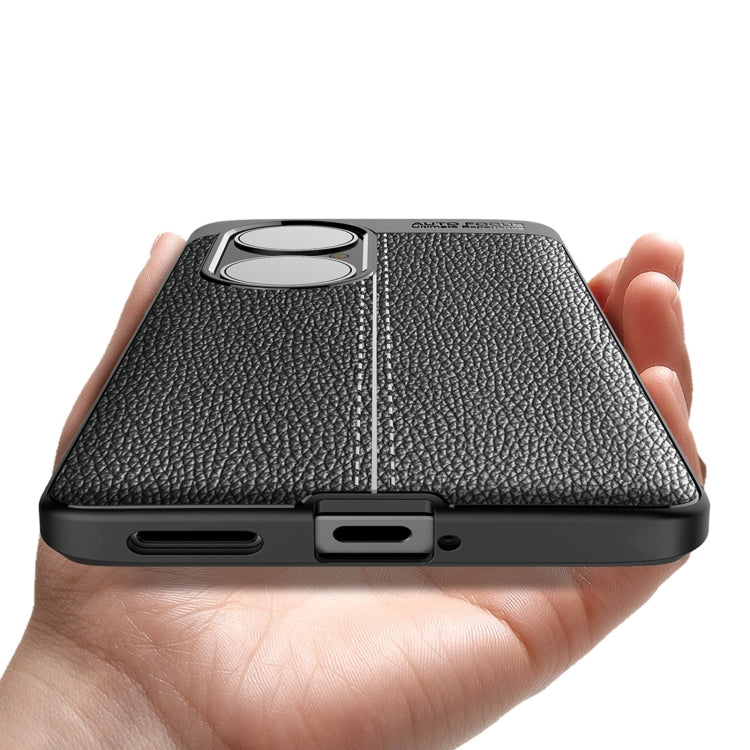 Black textured TPU phone case held in hand, with dual camera lens cutout