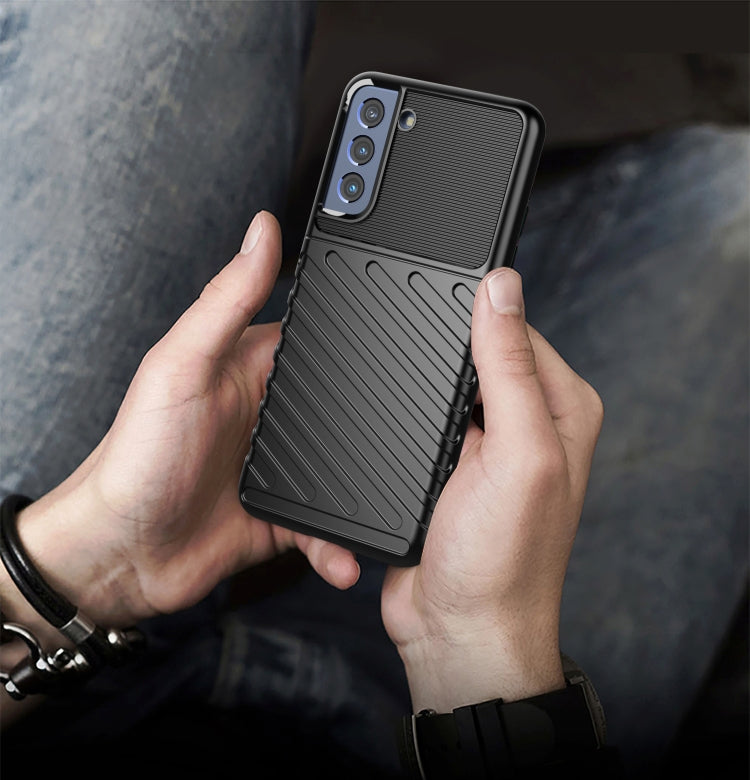 Black shockproof TPU phone case with ribbed texture and camera openings in hands