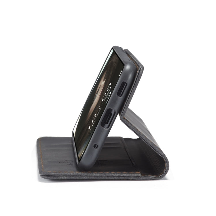 Black leather phone case displayed on its stand with flip cover open