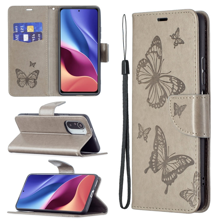 Gray leather phone case with embossed butterflies, card slot, and lanyard