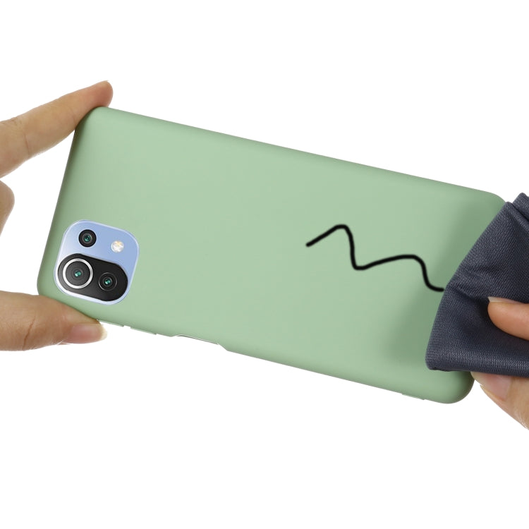 Green liquid silicone protective phone case shown being stretched over the phone.