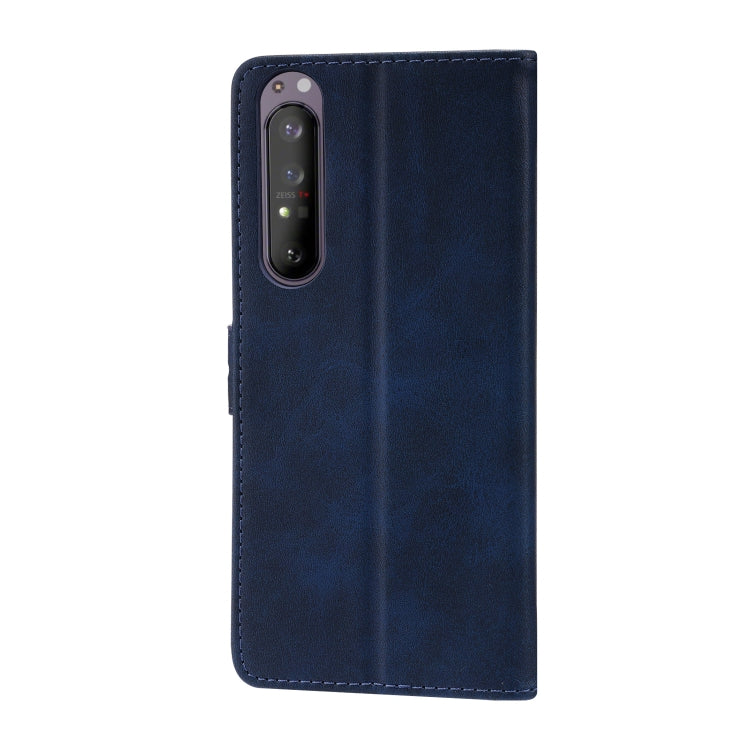 Blue leather phone case with stitched edges and embossed cat on the back