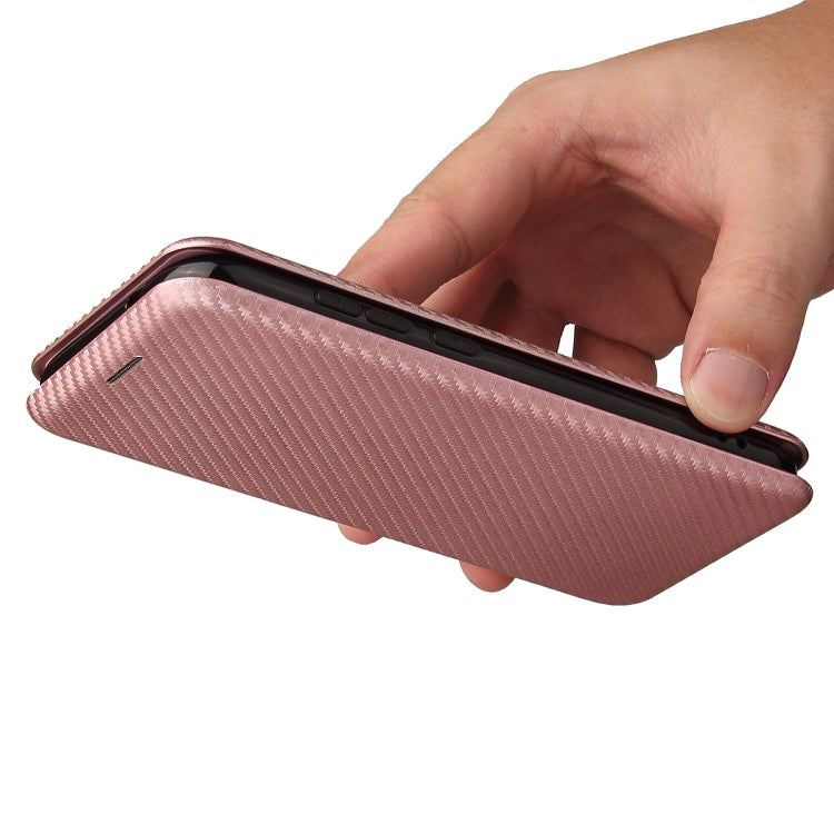 Pink magnetic flip phone case with carbon fiber texture, shown in hand