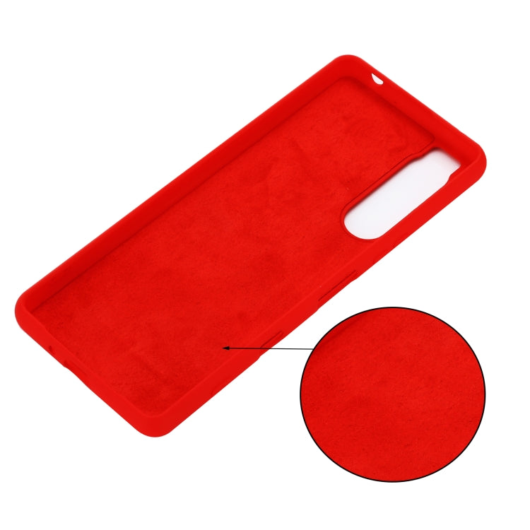 Red liquid silicone phone case back panel with cutout opening and small piece