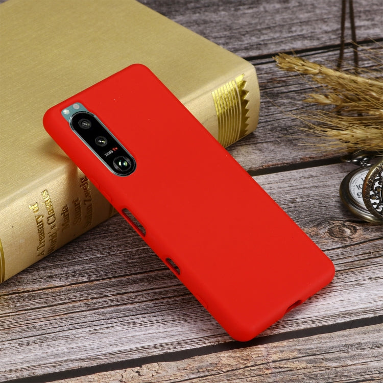 Red liquid silicone phone case with camera opening and side port cutouts