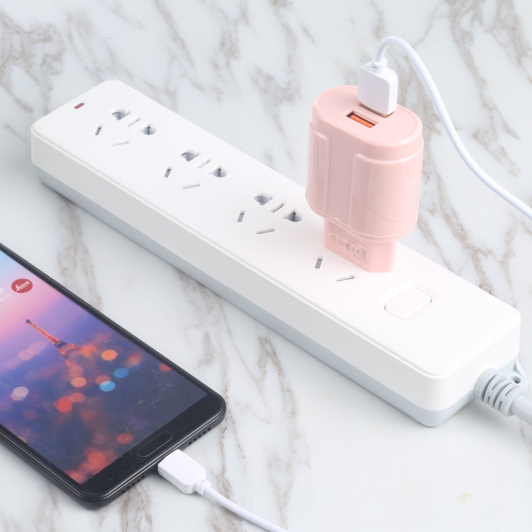 Pink dual-USB EU travel charger plugged into a power strip, USB ports visible