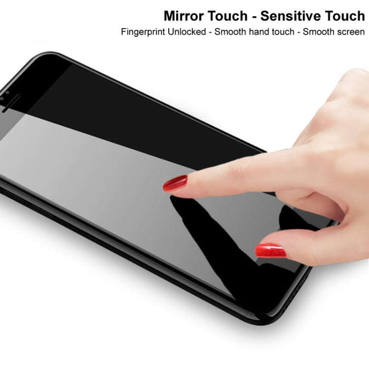 Hand smoothing a tempered glass screen protector on a smartphone display