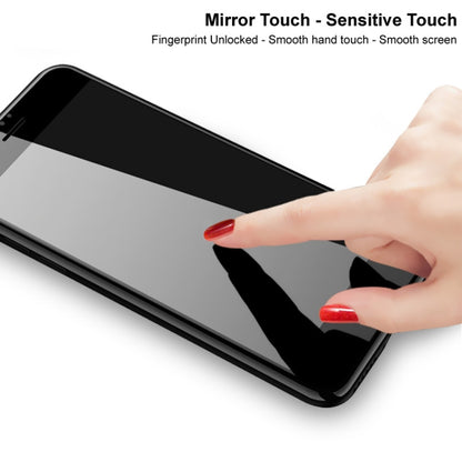 Hand smoothing a tempered glass screen protector on a smartphone display