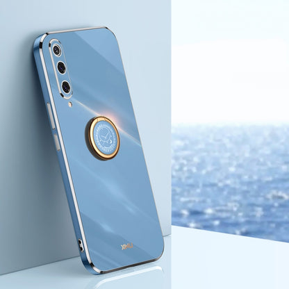 Glossy light blue phone case with gold-tone ring holder and camera cutouts