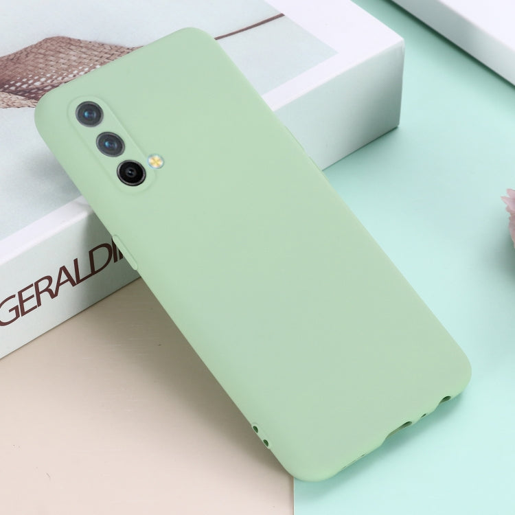 Mint green silicone phone case angled view, showing triple camera cutouts.