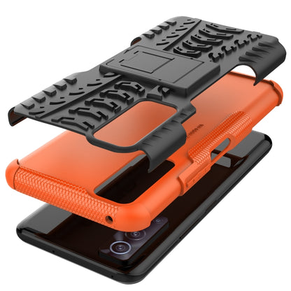 Orange-and-black rugged phone case with holder shield and textured tire tread
