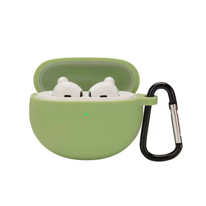 Matcha green silicone earbud case with hook, holding two white earbuds in a lid-open shell