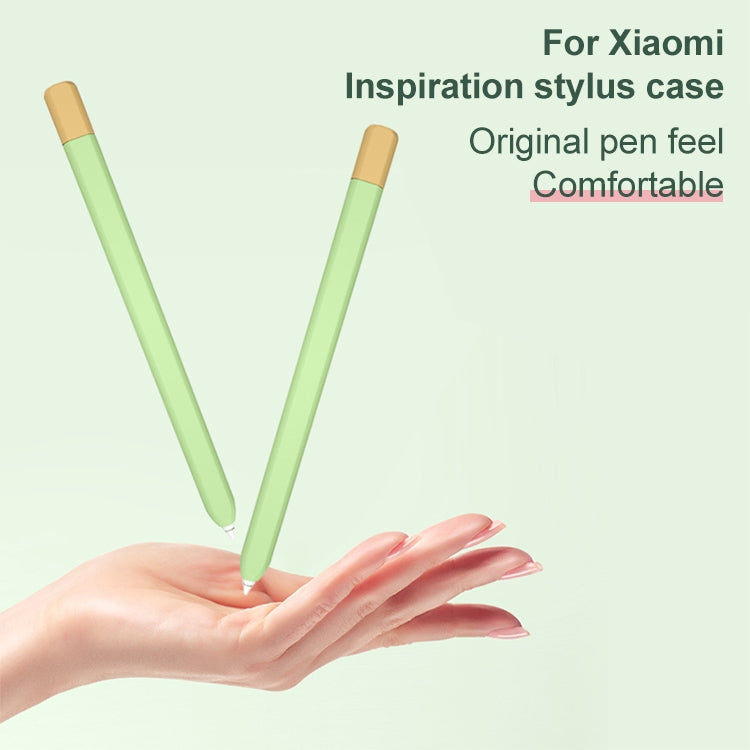 Two stylus pen protective cases on hand, light green bodies with tan caps