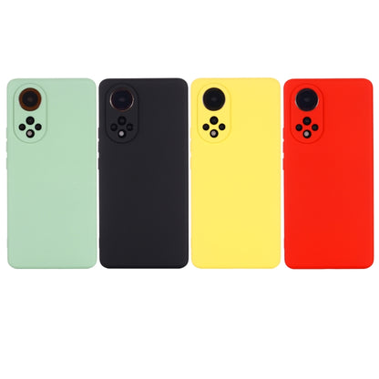 Liquid silicone phone cases in mint, black, yellow, and red with camera cutouts