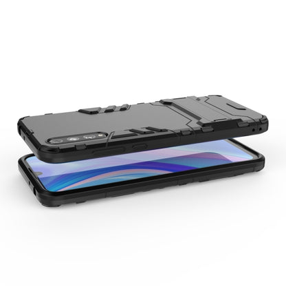 Rugged shockproof phone case in black, phone lying flat with camera guard
