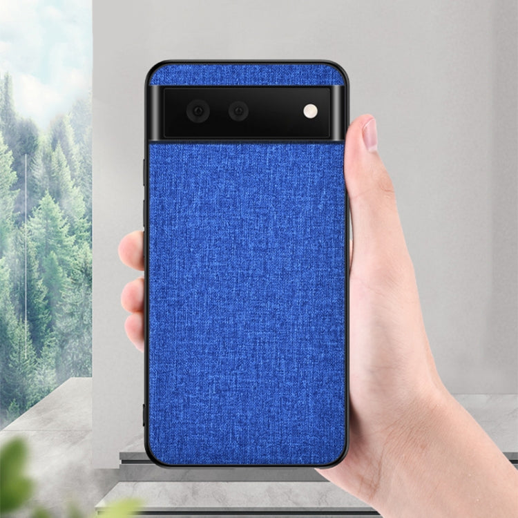 Blue textured phone case held upright, showing dual camera cutouts and black edges
