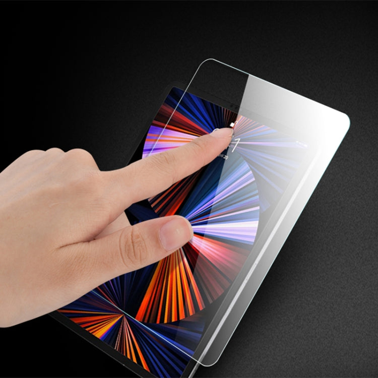 Hand installing tablet tempered glass screen protector, clear film covering display