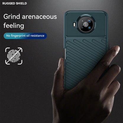 Dark teal TPU phone case shown with hand, featuring textured back and camera cutout