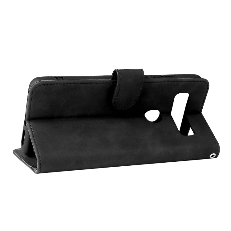 Black folio leather phone case in stand view with magnetic strap and cutouts.