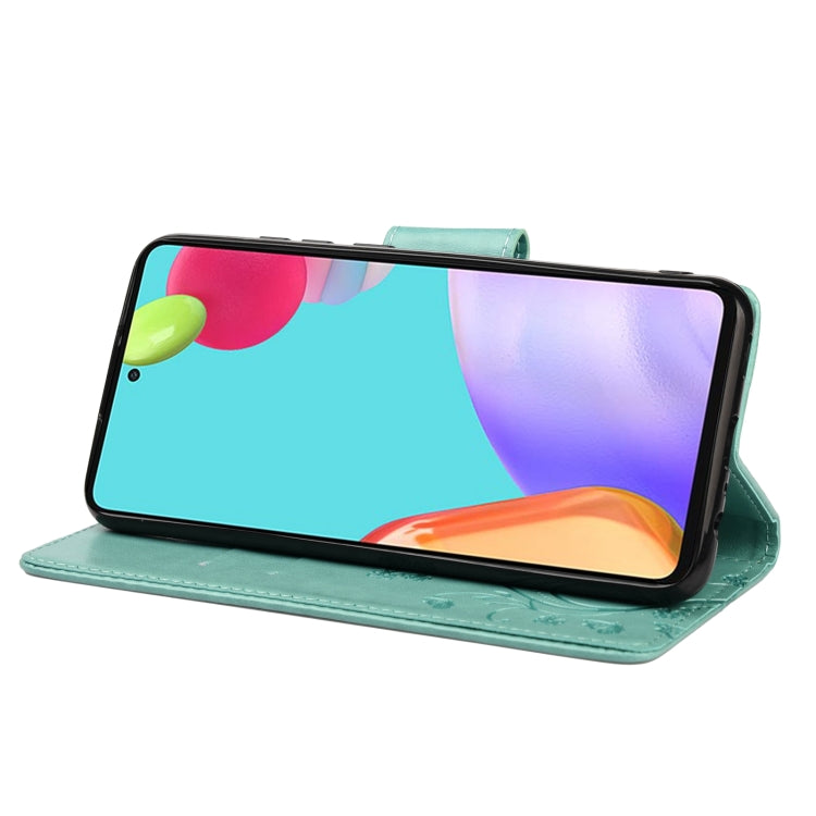 Green leather folio phone case with butterfly-flower pattern, kickstand view