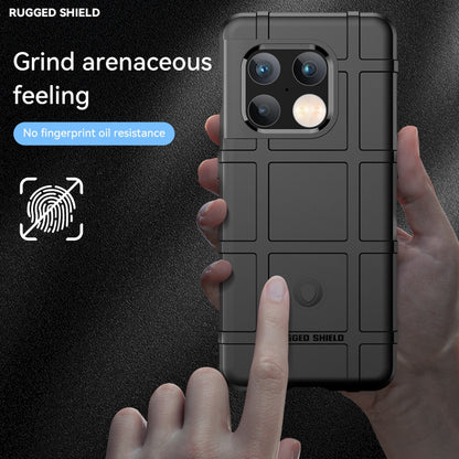 Black rugged TPU phone case held in hand, showing camera cutouts and textured back
