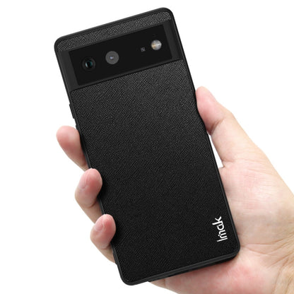 imak LX-5 phone case with screen protector, cross-texture dark finish, held in hand