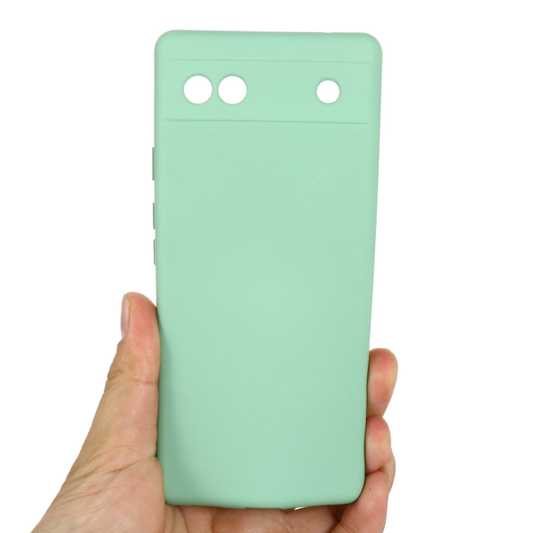 Mint green silicone phone case for Pixel 6a, back held in hand