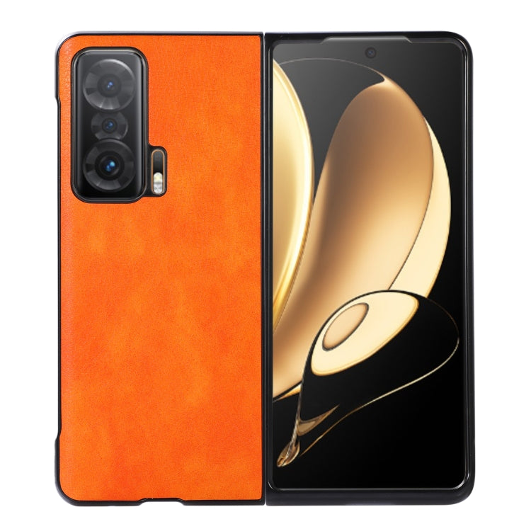 Orange litchi-textured phone case with black edge trim, triple-camera cutout and raised lip